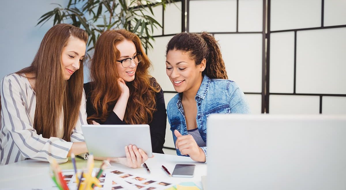 smiling-businesswomen-looking-at-digital-tablet-at-95VB2QG-1.jpg